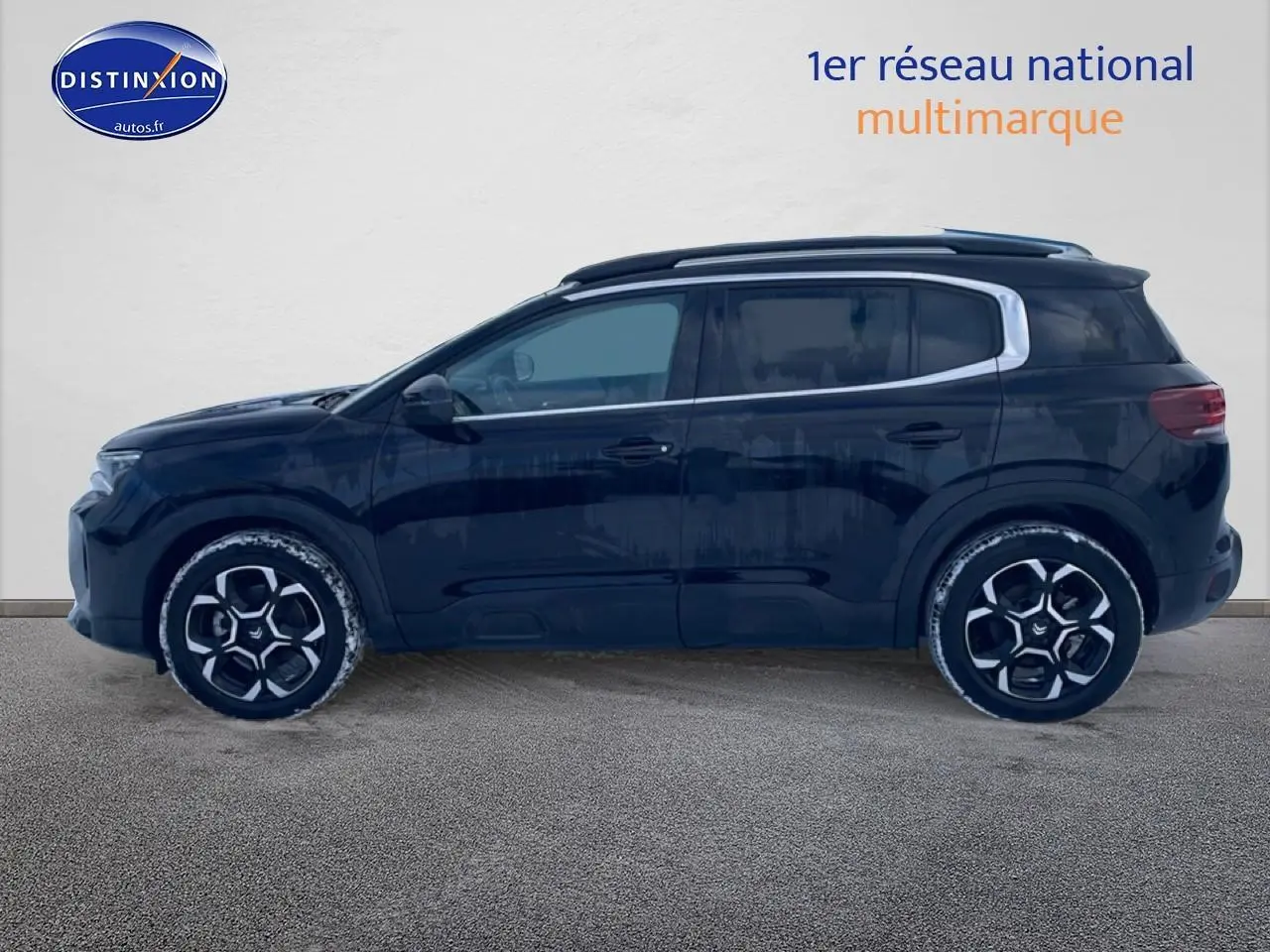 Profil côté gauche d'un Citroën C5 Aircross noir 2025 avec jantes alu et barres de toit visibles.