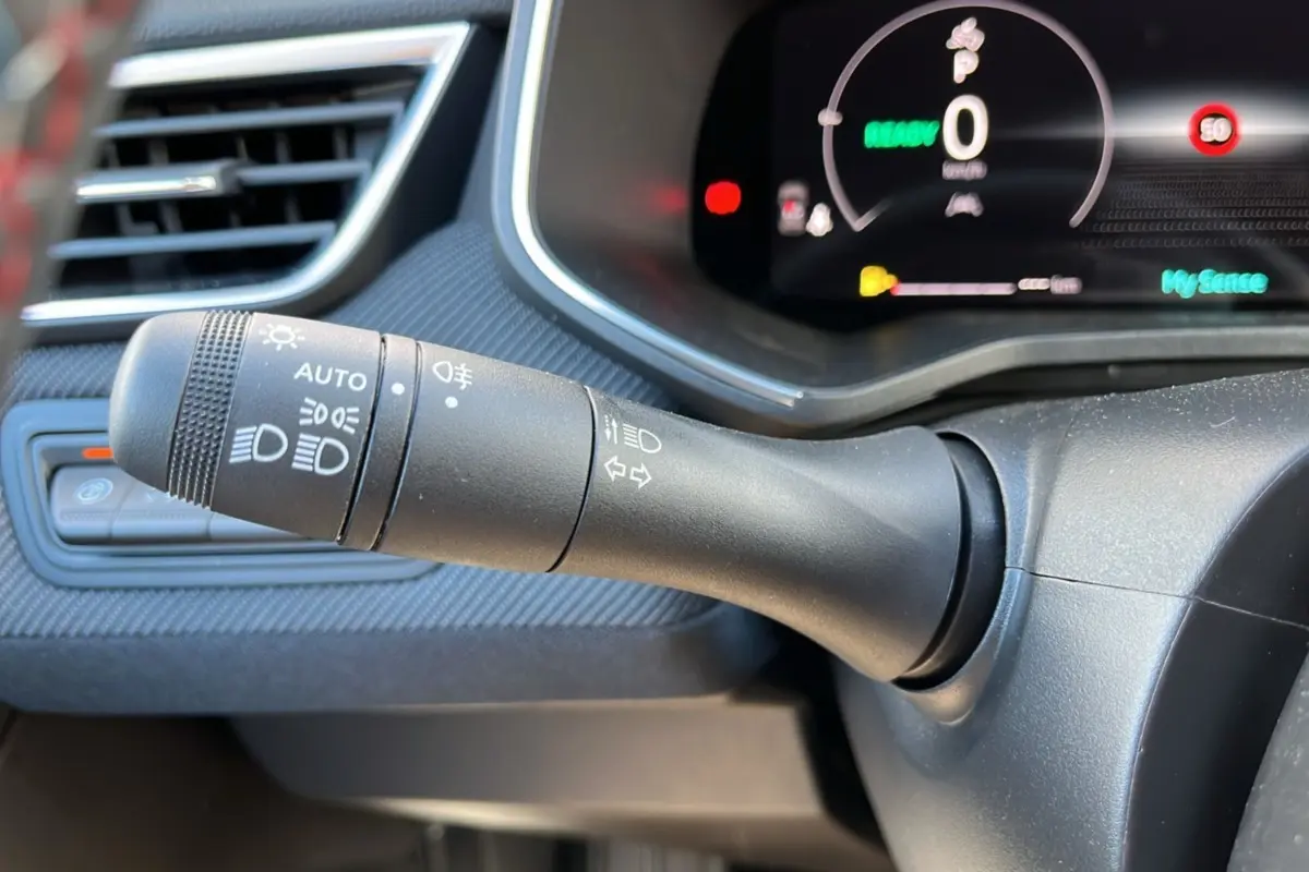 Gros plan sur la commande des feux et clignotants dans l’habitacle de la Renault Clio V E-Tech 145 Esprit Alpine.