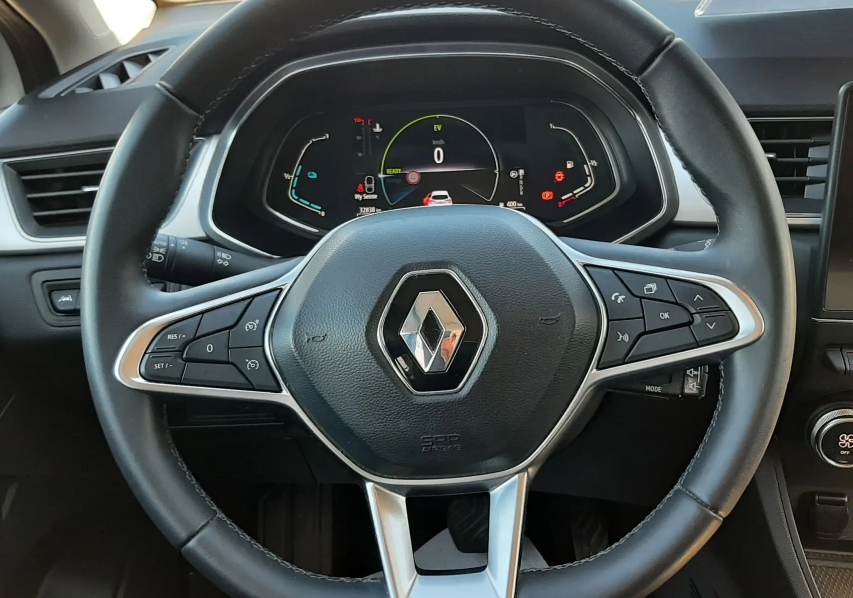 Vue rapprochée du volant noir de la Renault Captur E-Tech 145ch Intens 2022 avec tableau de bord numérique allumé.
