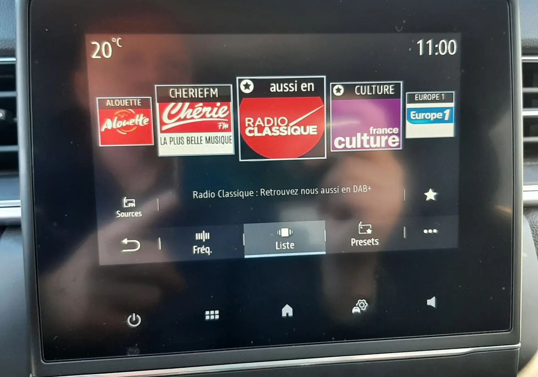 Écran tactile central du tableau de bord du Renault Captur blanc nacré, affichant les stations radio avec commandes en dessous.