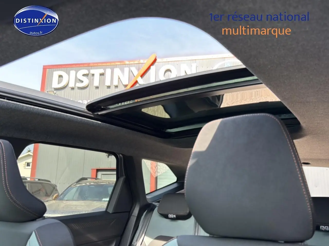 Vue intérieure du toit ouvrant panoramique et des sièges avant gris du Dacia Bigster 2026, avec ciel visible à l'extérieur.