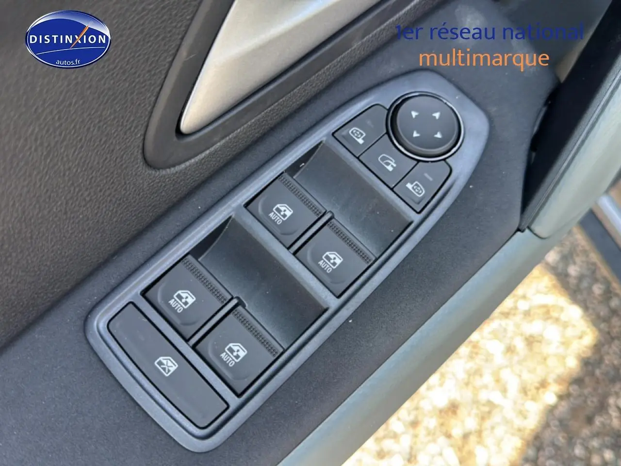 Gros plan sur les commandes des vitres électriques et rétroviseurs sur la porte côté conducteur du Dacia Bigster gris schiste.