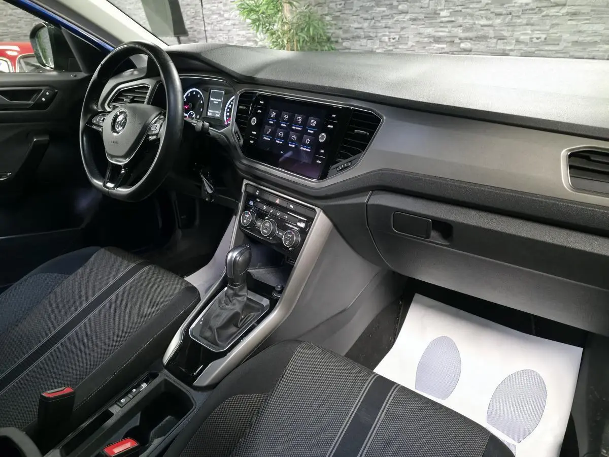 Intérieur avant droit du Volkswagen T-Roc 2020, tableau de bord noir avec écran tactile et sellerie tissu sombre.