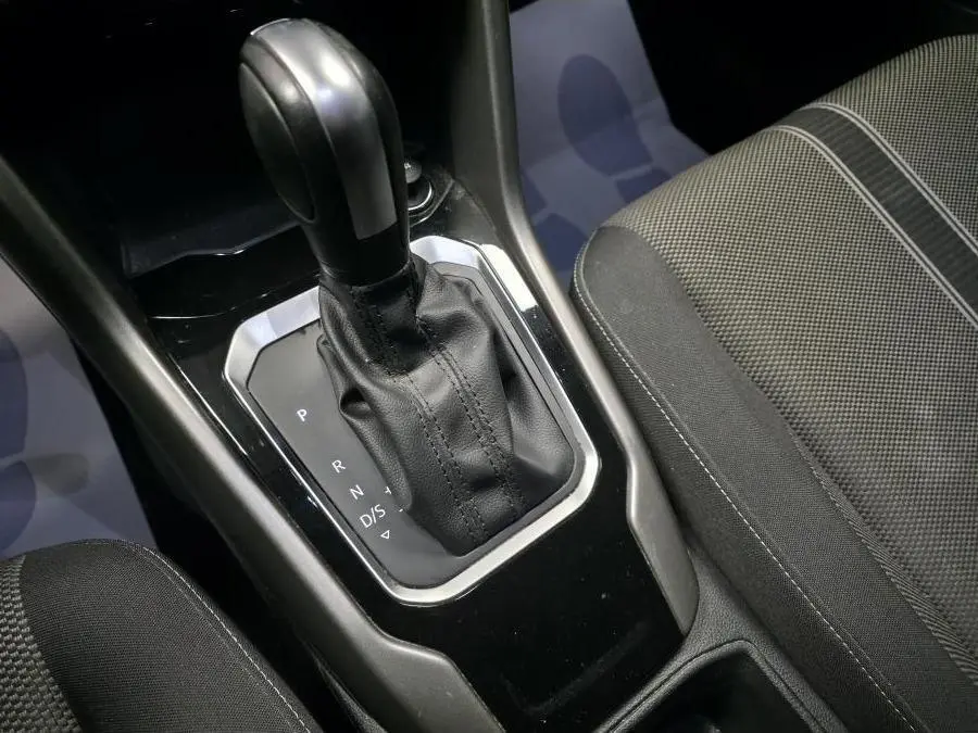 Gros plan sur le levier de vitesses automatique noir et cuir du Volkswagen T-Roc 1.5 TSI Evo Lounge, intérieur tissu gris.