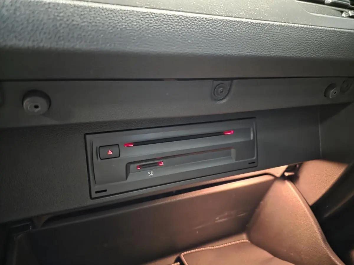 Gros plan sur le lecteur SD et CD dans la boîte à gants du Volkswagen T-Roc 1.5 TSI Evo bleu foncé, intérieur noir.