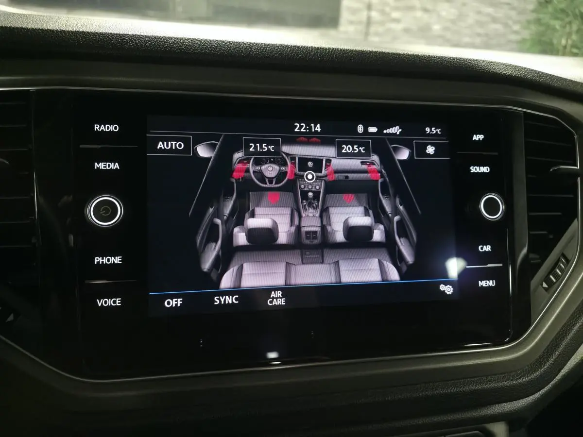 Écran tactile central affichant la vue intérieure du Volkswagen T-Roc avec réglages climatisation bi-zone.