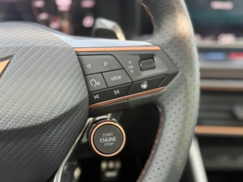 Détail du volant perforé du CUPRA Formentor 2.0 TDI 150ch avec bouton start/stop et finitions cuivrées.