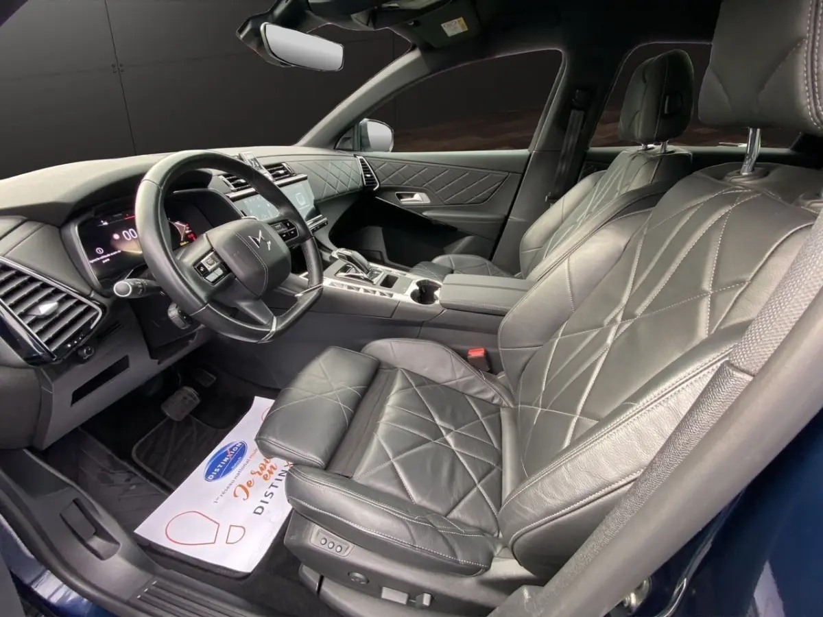 Vue intérieure côté conducteur du DS7 Crossback 2024, sièges cuir noir matelassé et tableau de bord moderne.