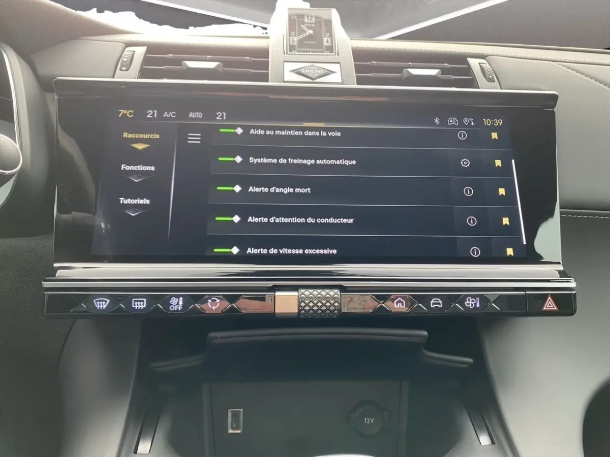 Vue rapprochée de l’écran tactile central du DS7 Crossback bleu, affichant les aides à la conduite et les commandes tactiles.