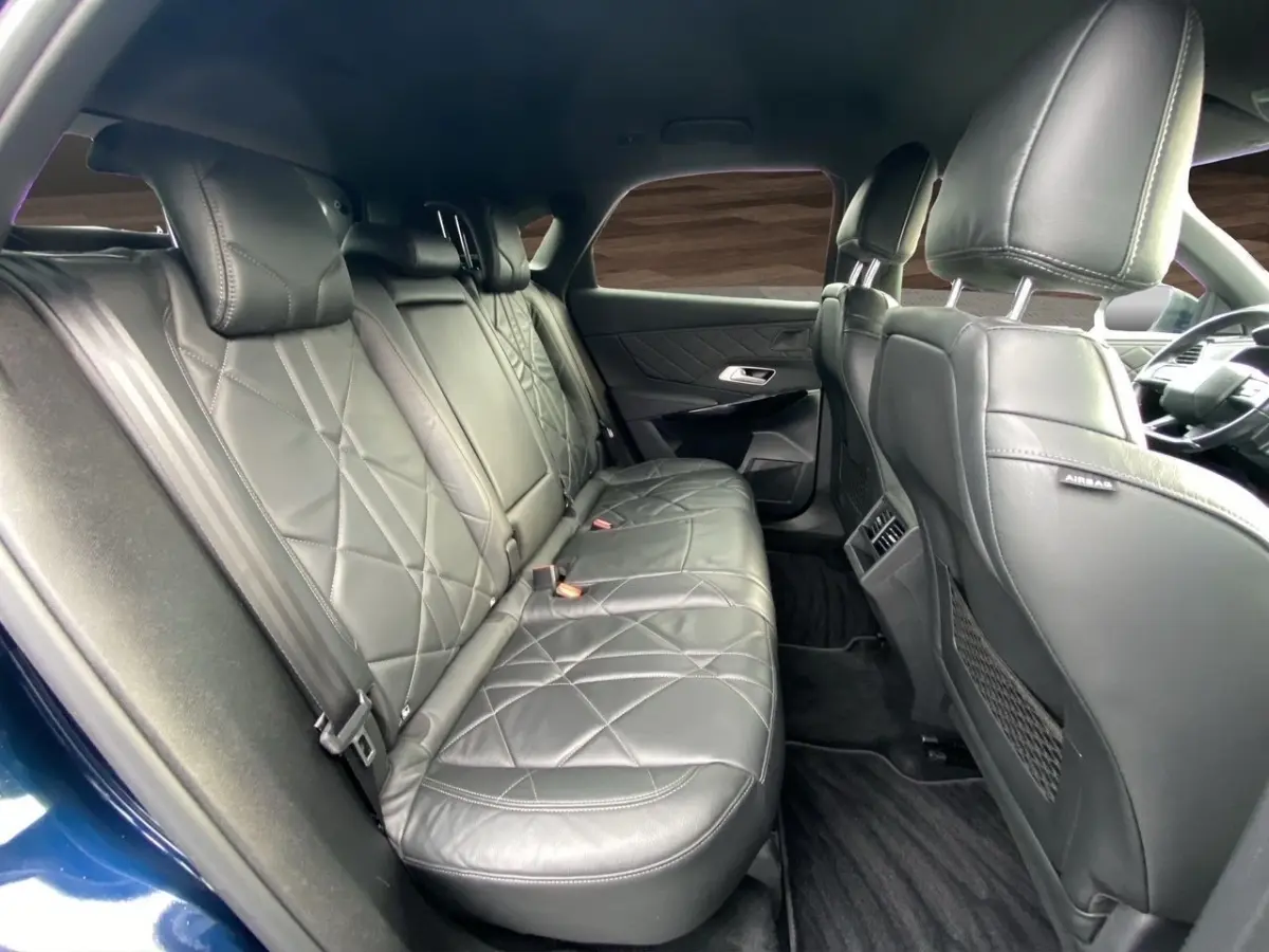 Vue intérieure côté droit des sièges arrière en cuir noir du DS7 Crossback Bleu, avec détails matelassés et accoudoirs.
