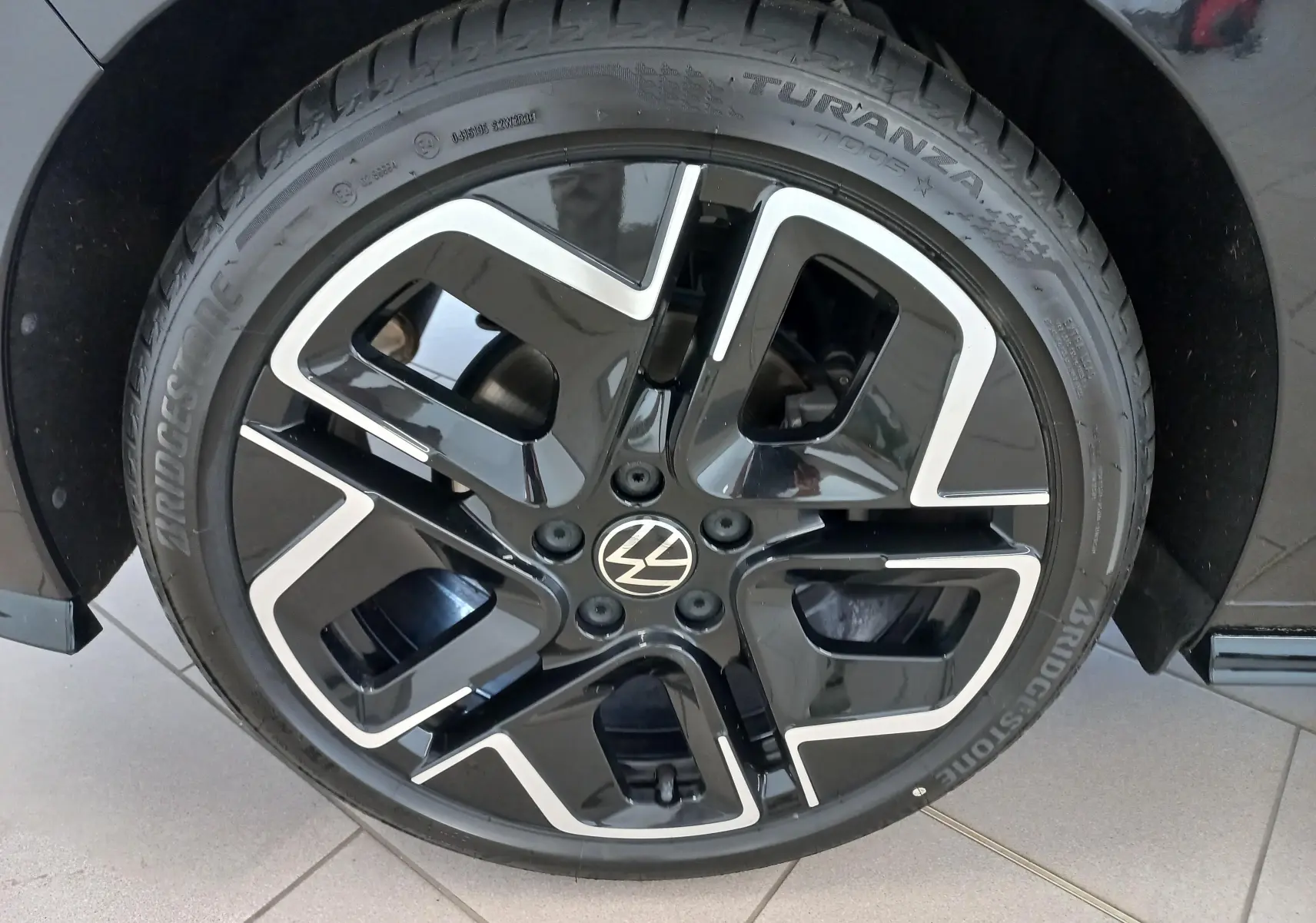 Gros plan sur la jante noire et argentée d'une Volkswagen Golf 1.5 eTSI 150 DSG7 R-Line Edition noir ébène.