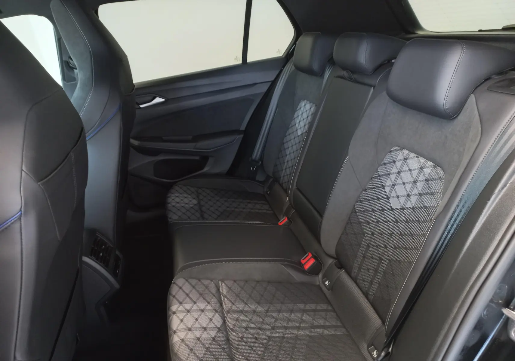 Vue intérieure côté droit des sièges arrière en tissu et cuir noir avec motifs géométriques d'une Volkswagen Golf 2025.