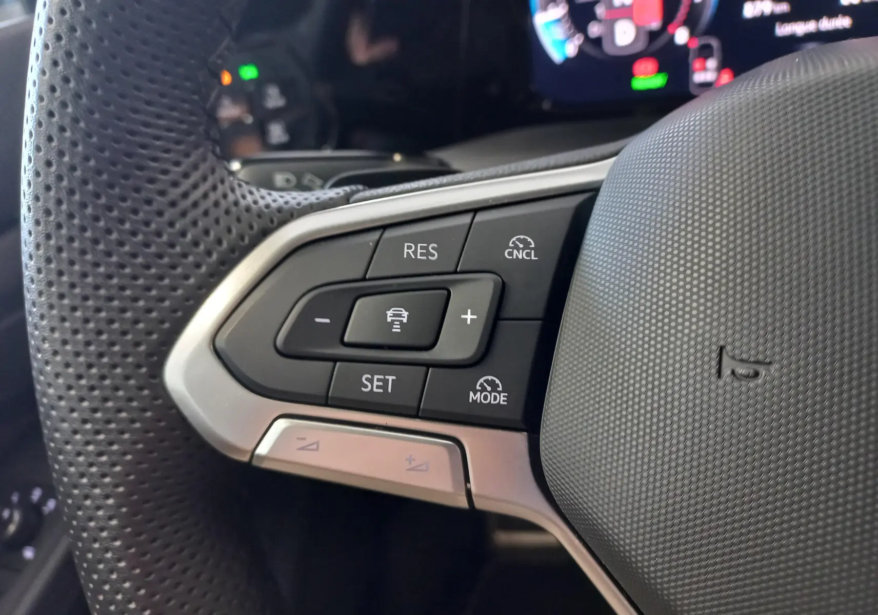Gros plan sur les commandes à gauche du volant perforé d’une Volkswagen Golf 1.5 eTSI 2025 finition R-Line.
