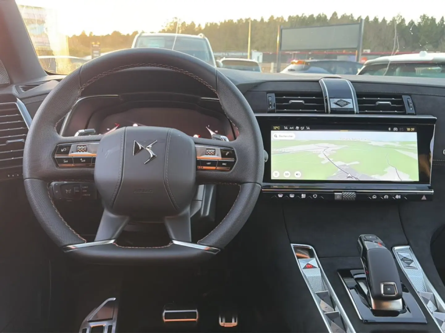Vue intérieure centrée sur le volant cuir et l'écran tactile large du tableau de bord du DS7 noir 2026.