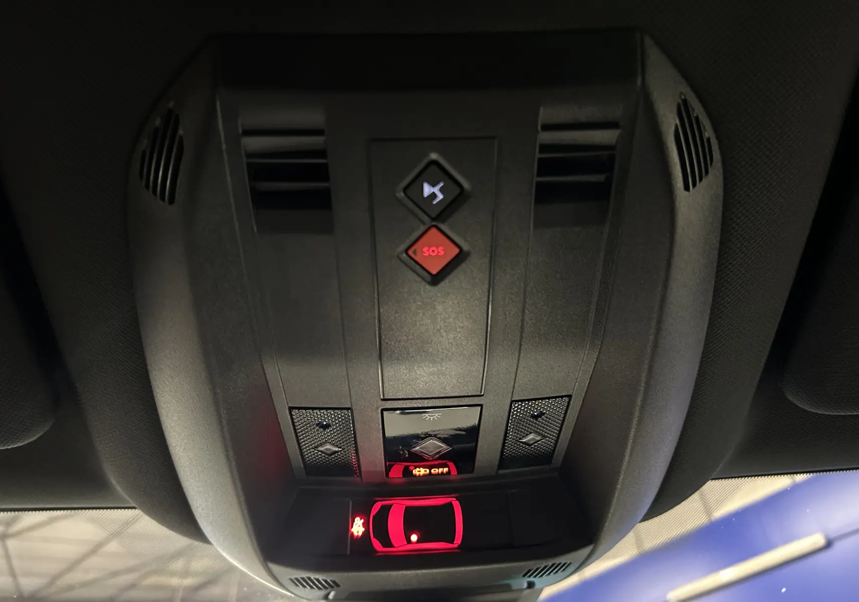 Vue en gros plan du plafonnier intérieur du DS7 2024 avec boutons SOS et signal sonore, éclairage rouge activé.