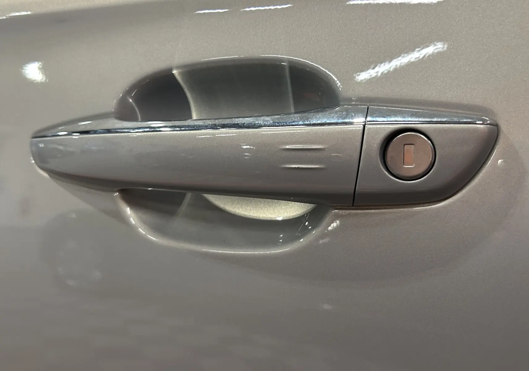 Poignée de porte côté gauche en gros plan sur DS7 2024 couleur Cristal Pearl avec serrure intégrée.