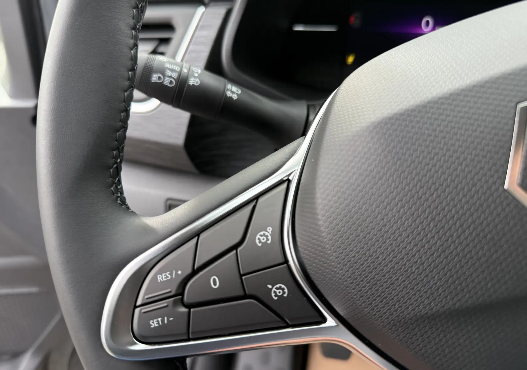 Gros plan sur le volant du Renault Trafic Combi 2025, mettant en valeur les commandes de régulateur de vitesse.