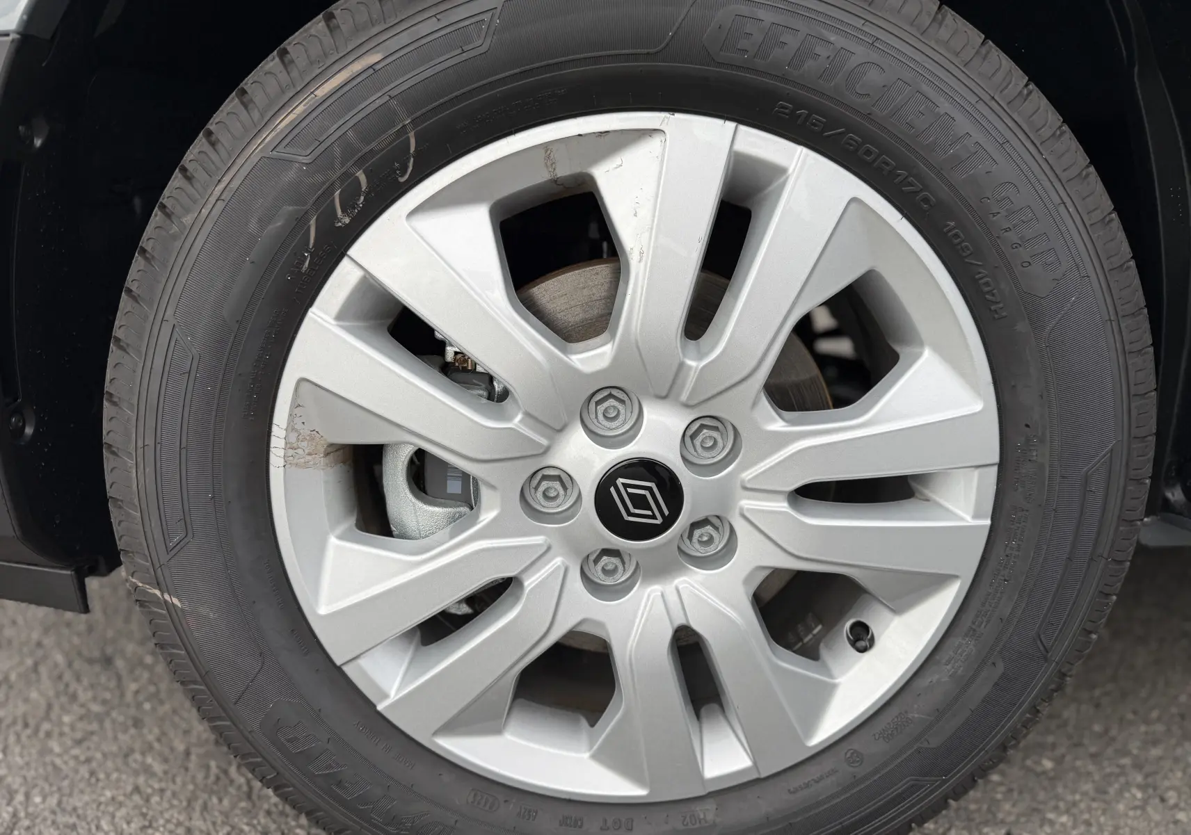 Gros plan sur la roue avant droite du Renault Trafic Combi gris urbain, avec jante alliage et logo Renault central.