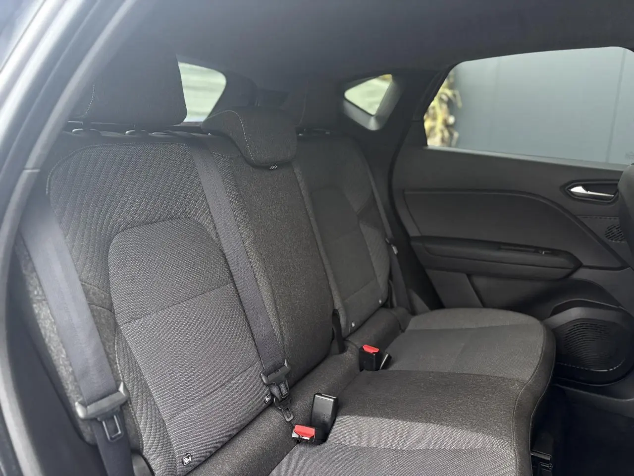 Vue intérieure côté droit des sièges arrière en tissu gris du Renault Captur 2025 bicarburation.