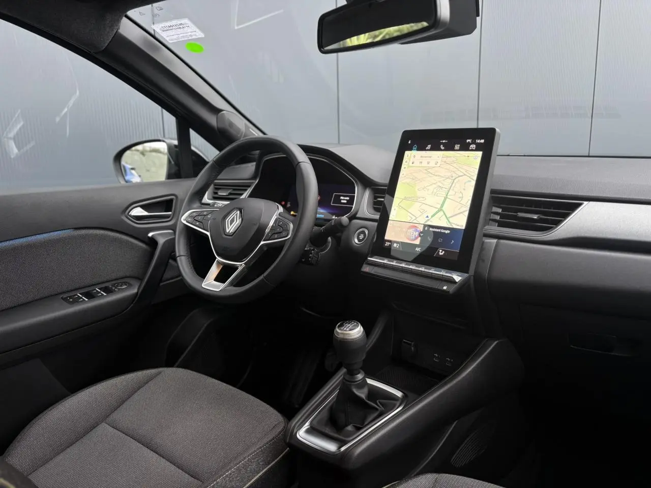 Vue intérieure côté conducteur du Renault Captur gris Cassiopée, avec tableau de bord numérique et écran tactile vertical OpenR Link.