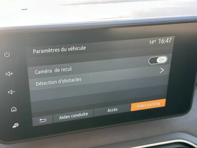 Écran tactile intérieur montrant les paramètres du véhicule Dacia Sandero 2025 avec options caméra de recul et détection d'obstacles.