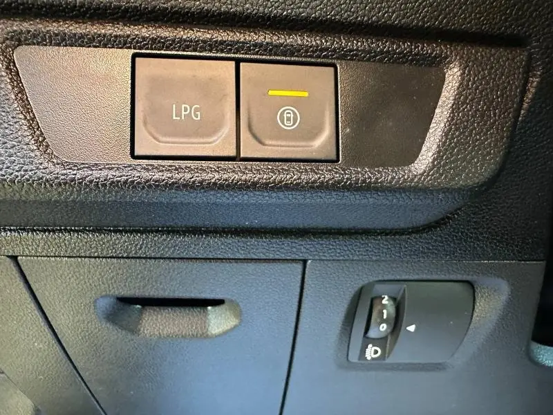 Gros plan sur les boutons de commande LPG et verrouillage dans l’habitacle du Dacia Sandero 2025 blanc.