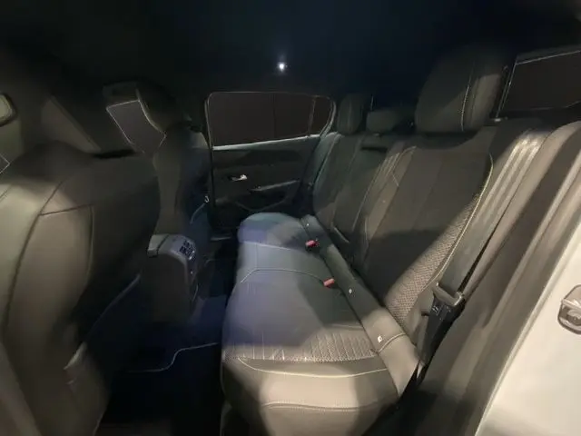 Vue intérieure arrière côté gauche de la banquette en cuir noir de la Peugeot 308 Hybrid 145 e-DCS6 GT 2026.