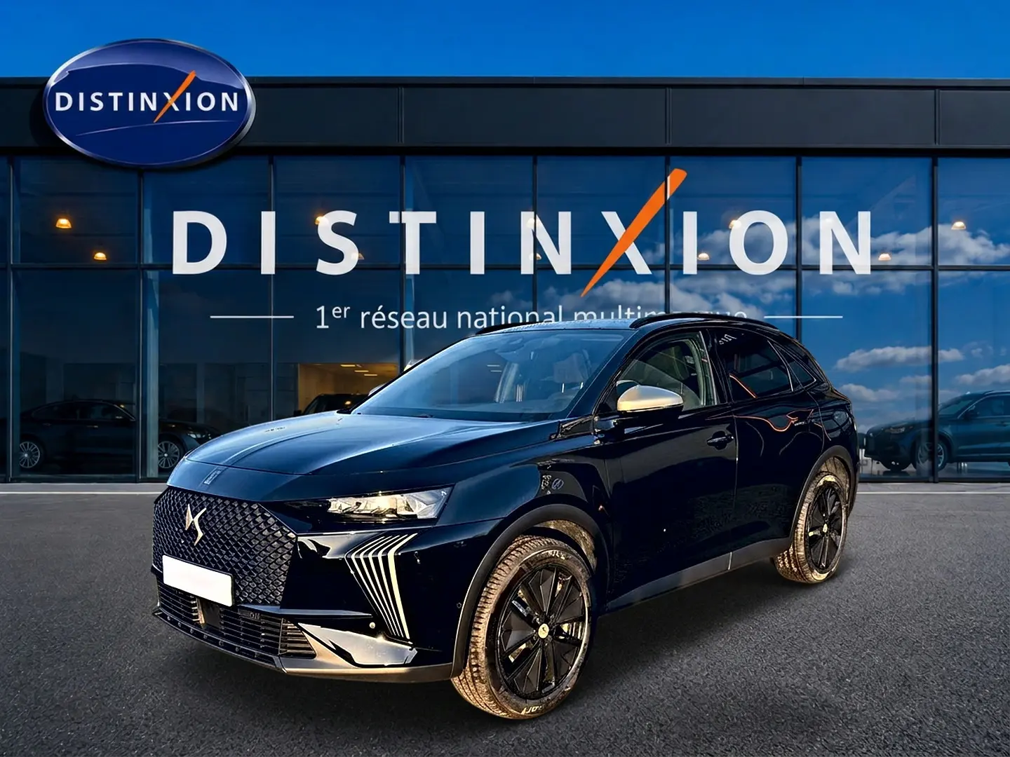 DS7 1.5 BlueHDi noir en 3/4 avant droit, avec calandre distinctive et jantes noires brillantes devant showroom Distinxion.