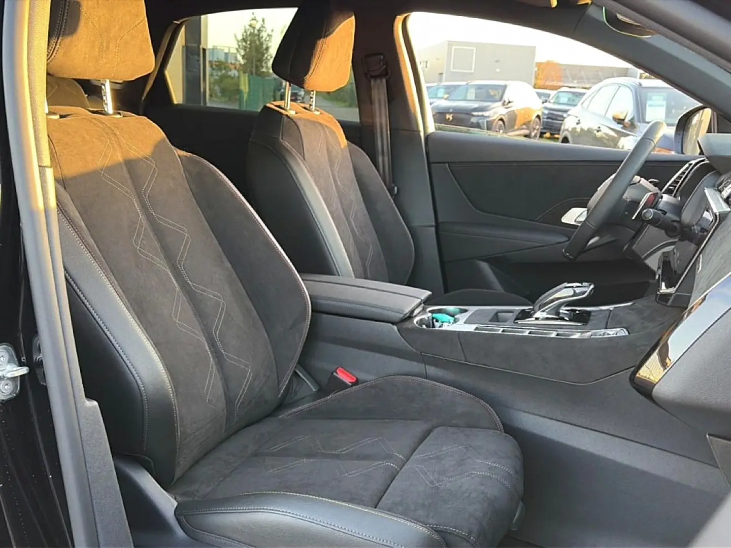 Vue intérieure côté conducteur du DS7 1.5 BlueHDi noir, sièges en alcantara avec surpiqûres et console centrale moderne.