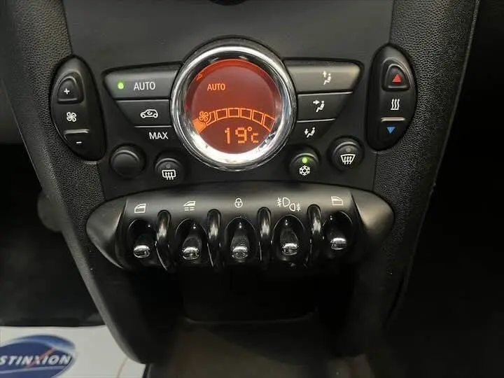 Panneau de commande de climatisation avec affichage orange et boutons noirs dans une MINI Cooper Cabriolet noire 2012