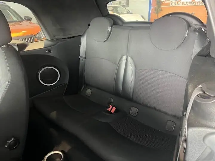 Vue intérieure arrière de la MINI Cooper cabriolet noire de 2012, sièges arrière en tissu noir avec appuie-têtes ronds.