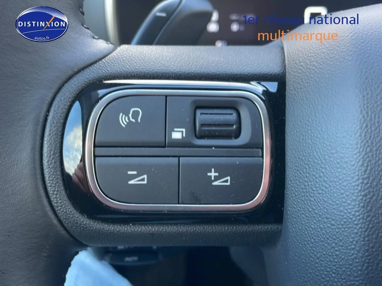 Gros plan sur les commandes vocales et volume au volant cuir noir du Citroën C5 Aircross gris platinium 2025.