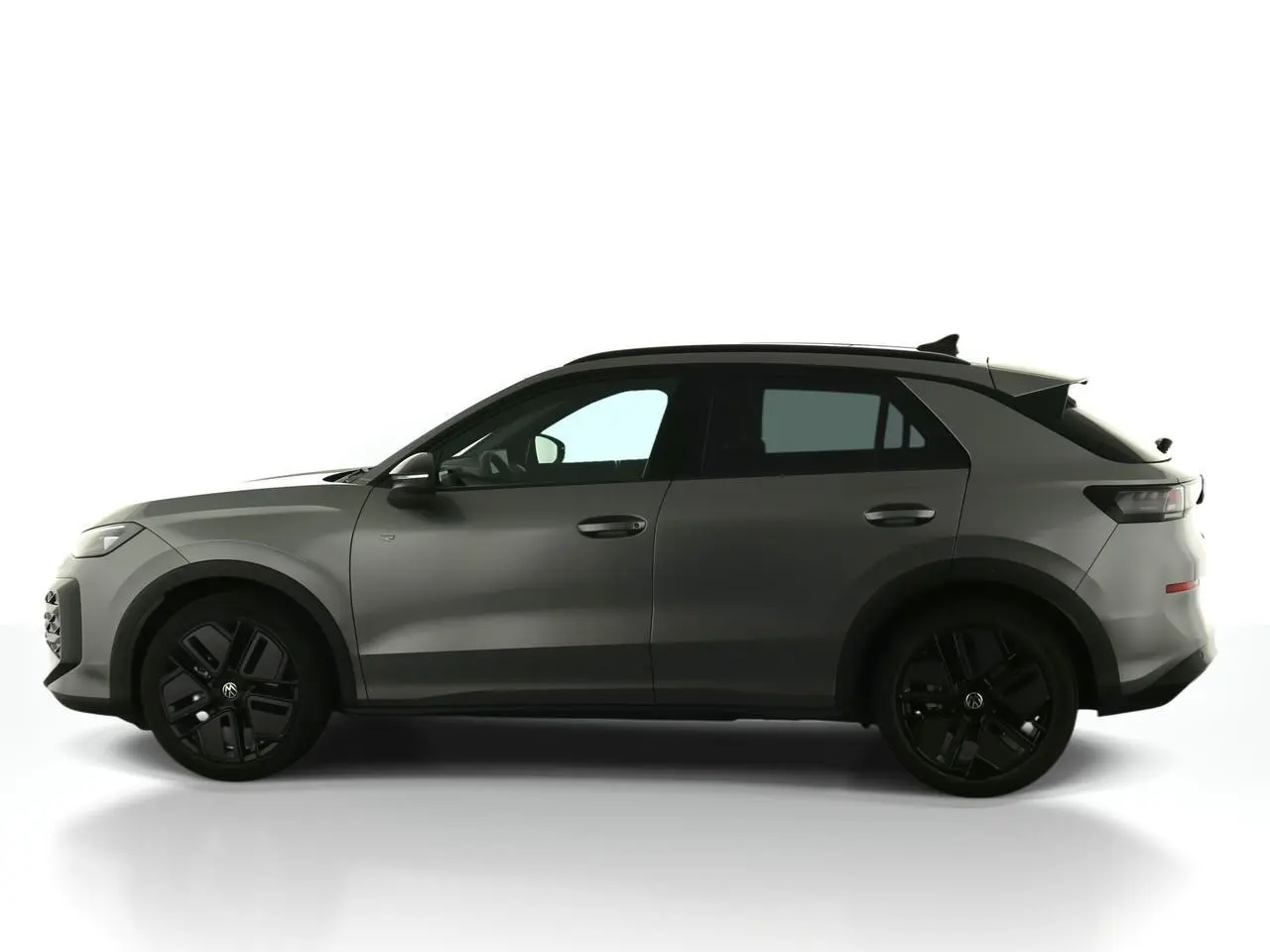 Vue de profil côté gauche du Volkswagen T-Roc 2026 gris Loup avec jantes noires sport et toit noir.