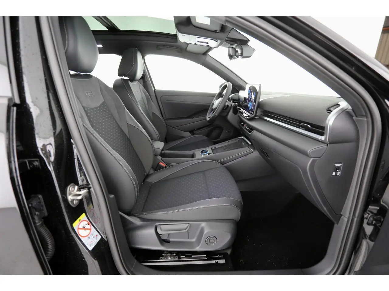 Vue intérieure côté conducteur du Volkswagen T-Roc 2026 avec sièges sport noirs et tableau de bord moderne.