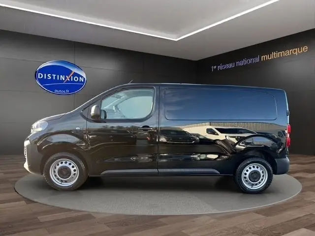 Vue de profil côté gauche d’un Peugeot Expert Fourgon noir 2025 dans un showroom avec logo Distinxion en arrière-plan.