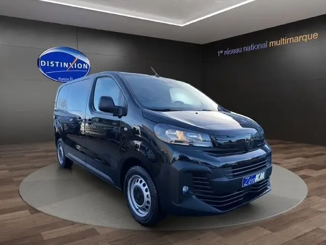 Vue 3/4 avant d’un Peugeot Expert Fourgon noir 2025 dans un showroom avec logo Distinxion en arrière-plan.