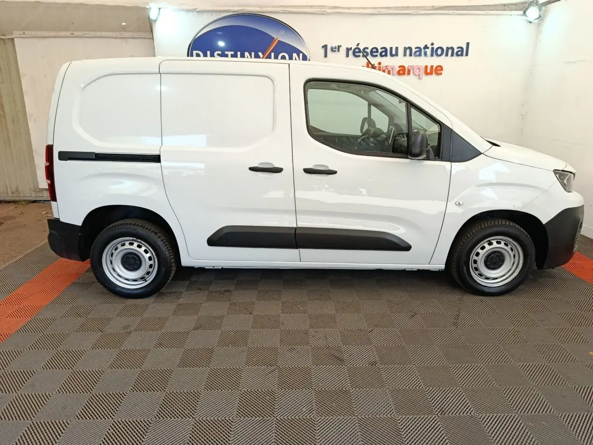Profil droit du Peugeot Partner blanc 2022, version utilitaire avec cloison pleine et jantes acier simples.