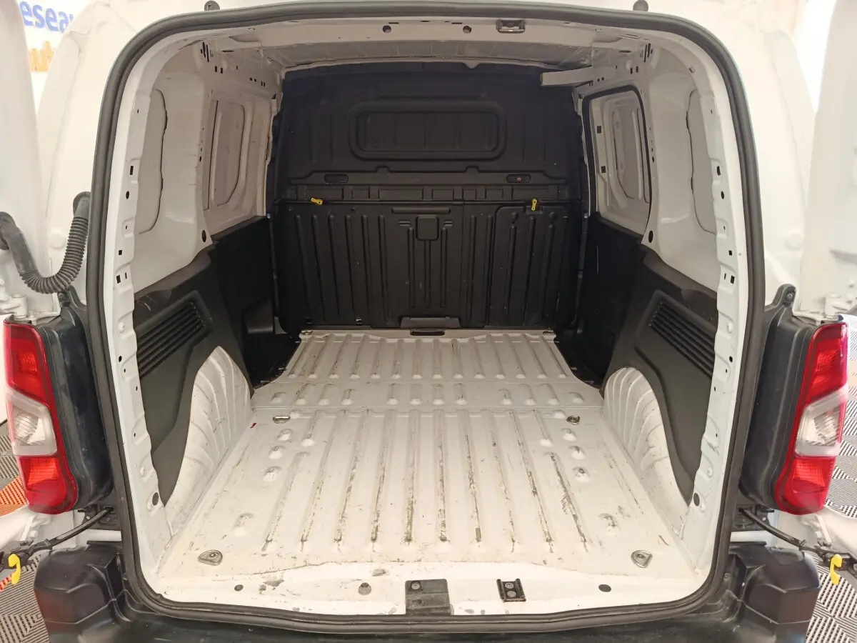Vue arrière du coffre blanc du Peugeot Partner Taille M 650kg, montrant l’espace de chargement vide avec cloison pleine noire.