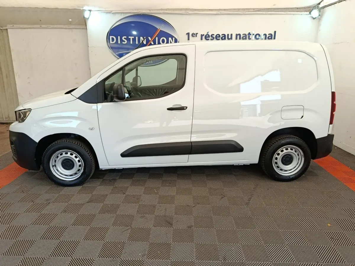 Vue de profil côté gauche d’un utilitaire Peugeot Partner blanc, version Taille M, avec porte latérale pleine et jantes acier.