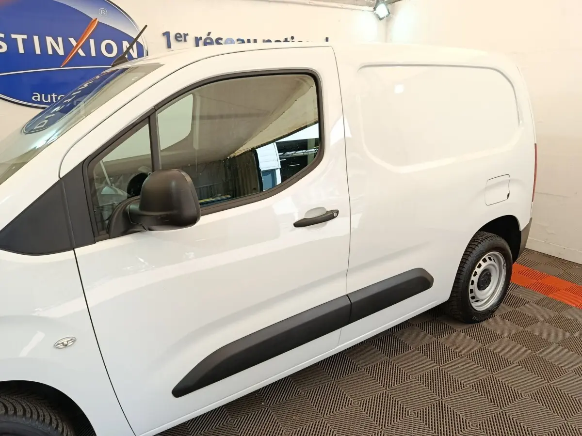Vue latérale droite d’un Peugeot Partner blanc 2022 avec porte latérale pleine et rétroviseur noir.