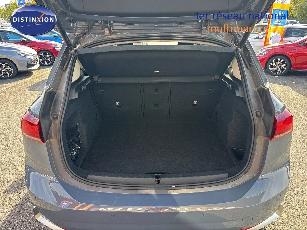 Coffre ouvert vu de l'arrière d'une BMW Série 2 Active Tourer 218d gris cuivré métallique sous lumière naturelle.