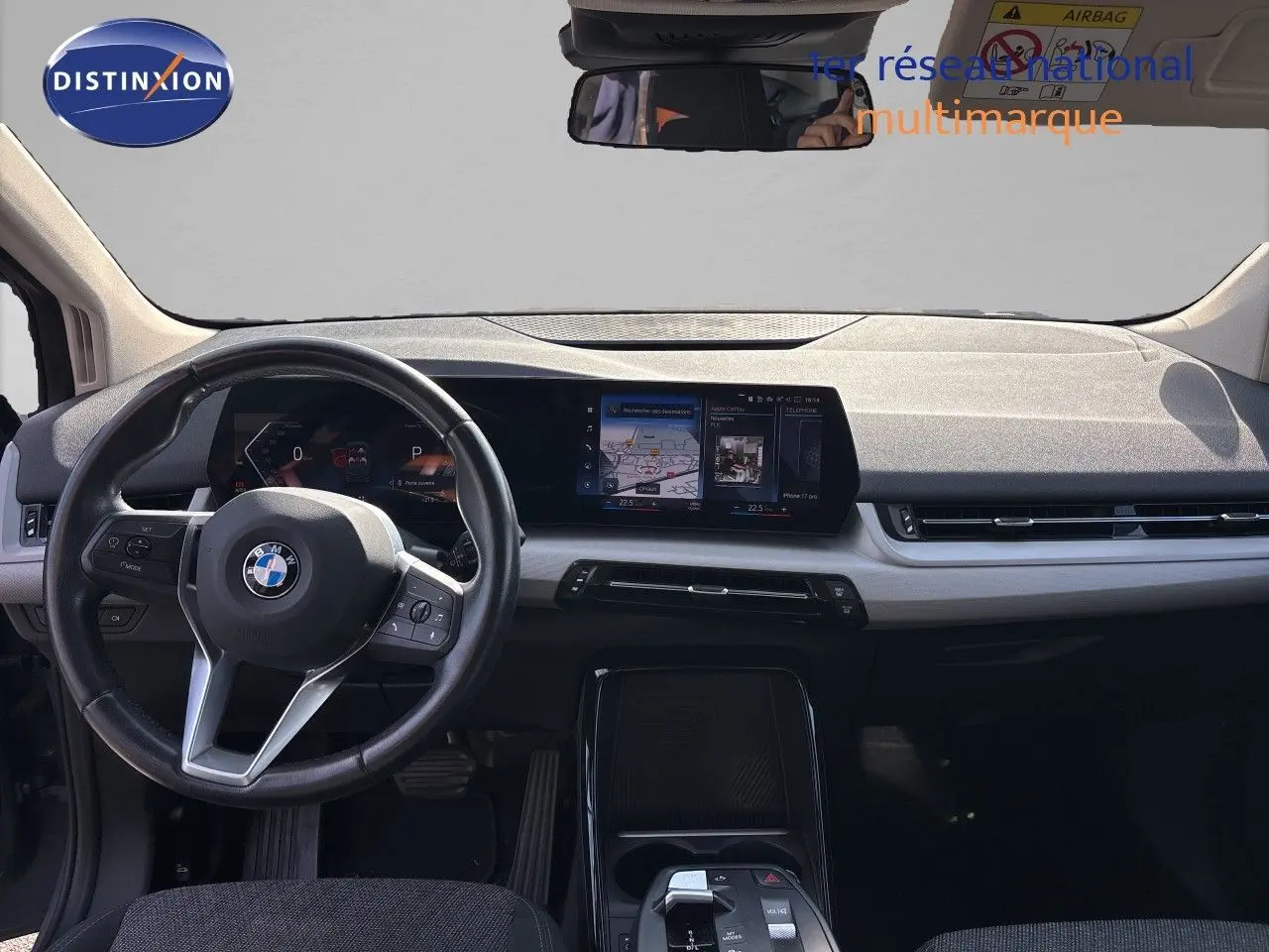 Vue intérieure avant du tableau de bord de la BMW Série 2 Active Tourer 218d gris cuivré avec écran tactile et volant cuir multifonction.