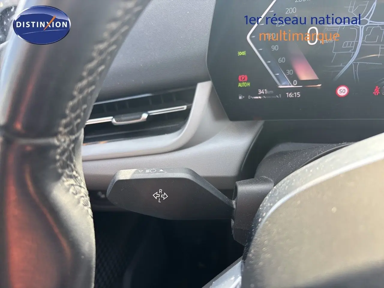 Gros plan sur le levier de clignotant à gauche du volant d’une BMW Série 2 Active Tourer 218d gris métallisé, tableau de bord digital visible.