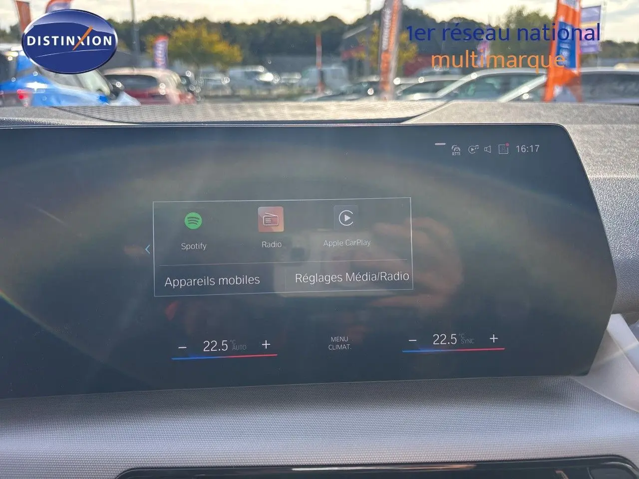 Vue intérieure du tableau de bord de la BMW Série 2 Active Tourer 218d, écran tactile affichant les réglages média et climatisation.