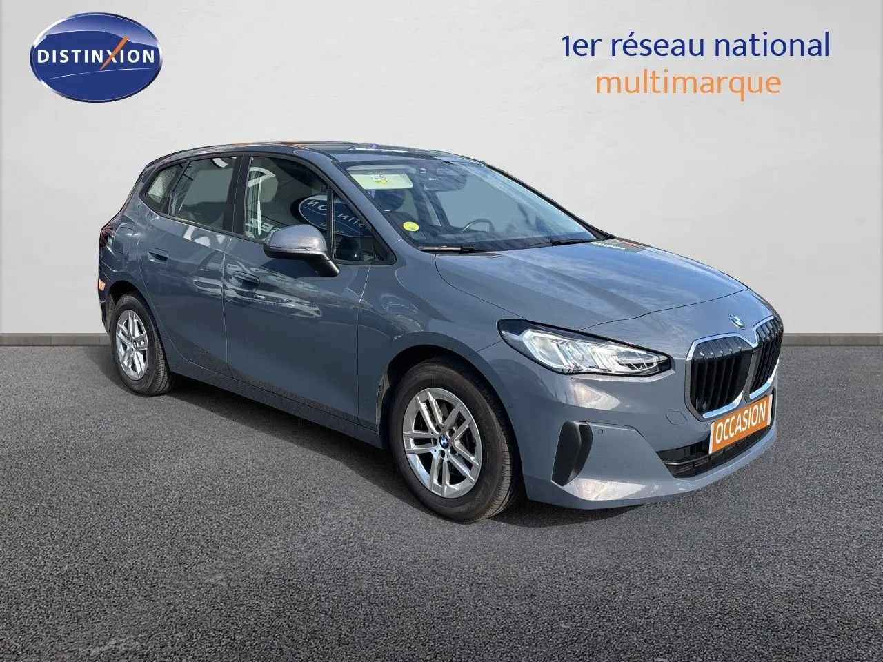 BMW Série 2 Active Tourer 218d gris Sparkling Copper, vue 3/4 avant droit sur fond neutre showroom.