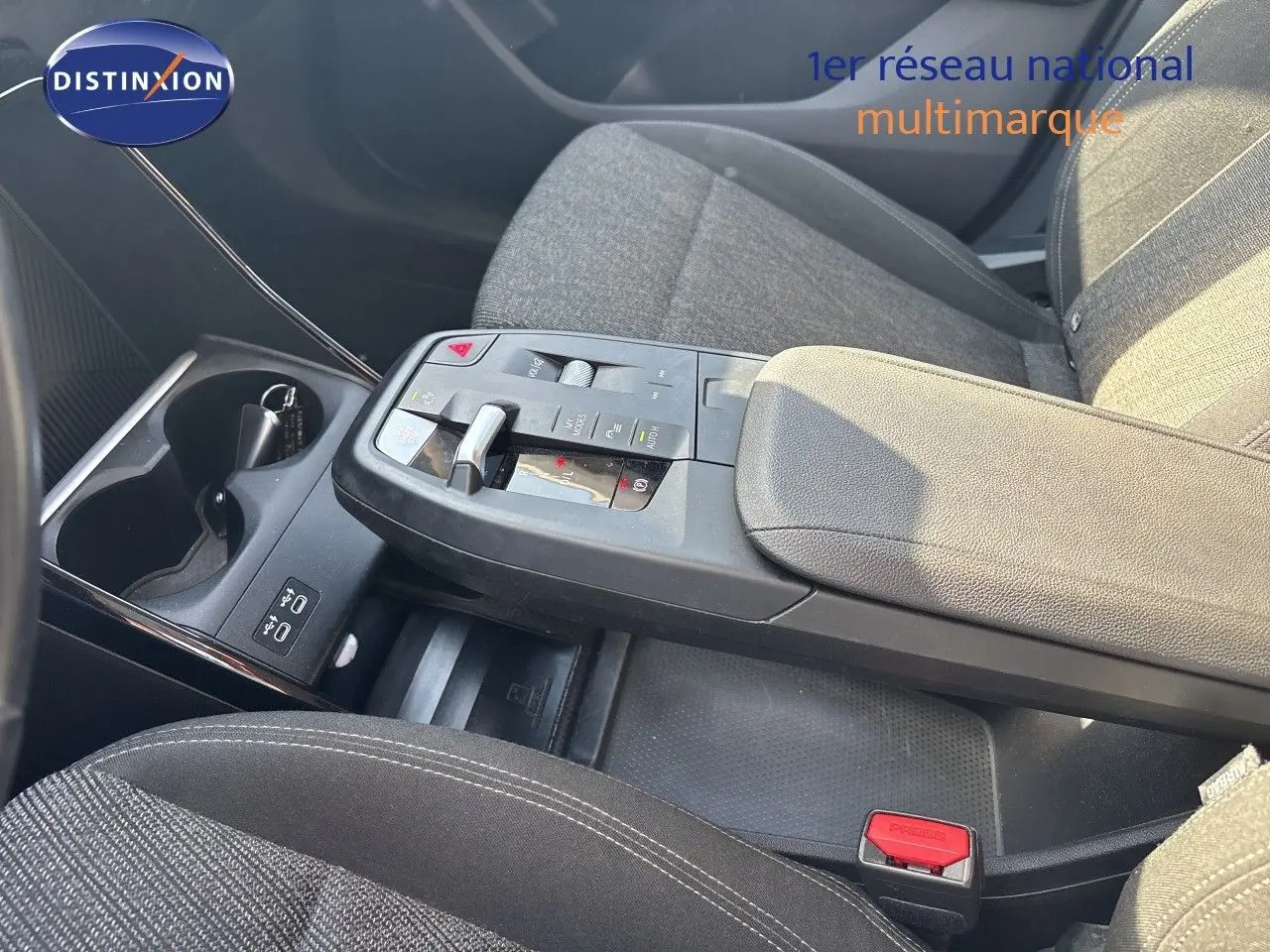 Vue rapprochée de la console centrale et accoudoir du BMW Série 2 Active Tourer 218d, tissu gris et commandes modernes.