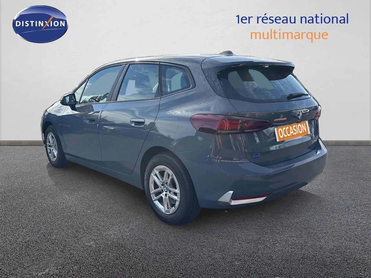 BMW Série 2 Active Tourer 218d gris cuivré vue 3/4 arrière droit sur fond neutre avec jantes alliage.