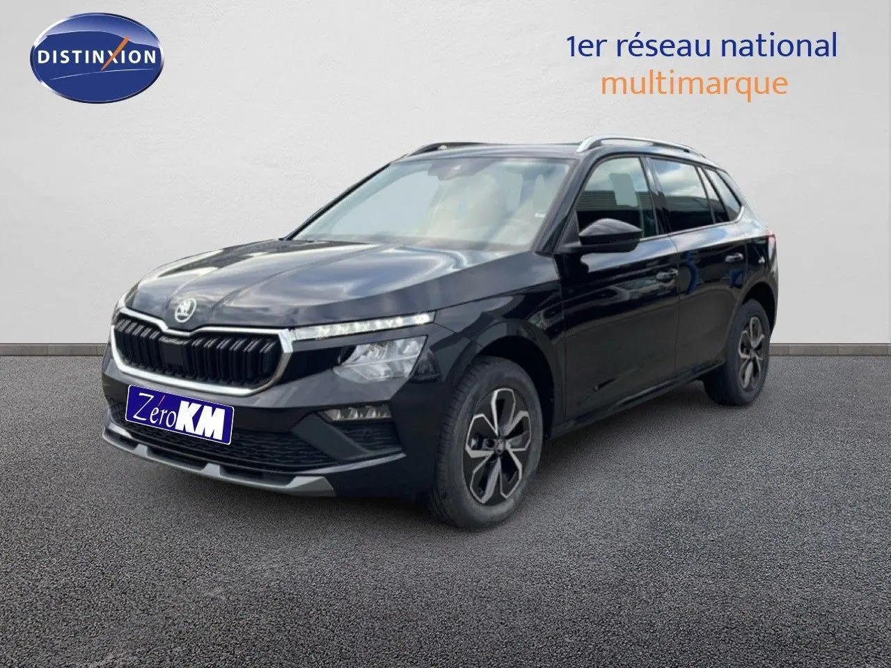 Vue 3/4 avant droite d’un Skoda Kamiq noir magique métal avec jantes bi-ton et barres de toit visibles.