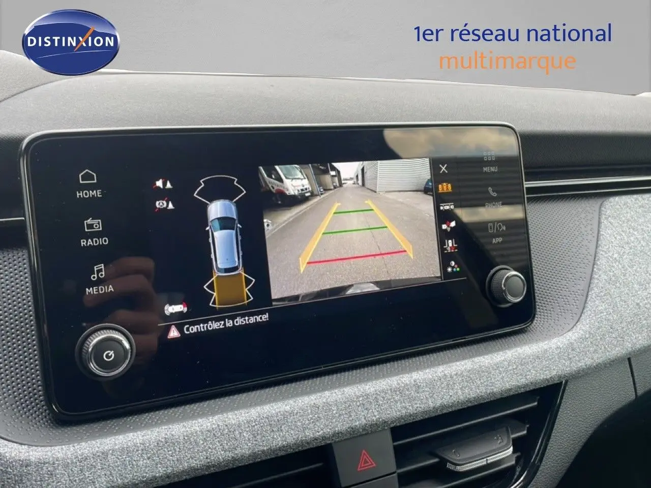 Écran tactile intérieur du Skoda Kamiq noir magique métal montrant la caméra de recul et l'aide au stationnement.