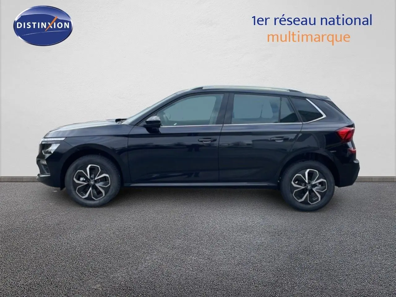 Vue de profil côté gauche d'un Skoda Kamiq noir magique métal avec jantes bi-ton et cinq portes visibles.